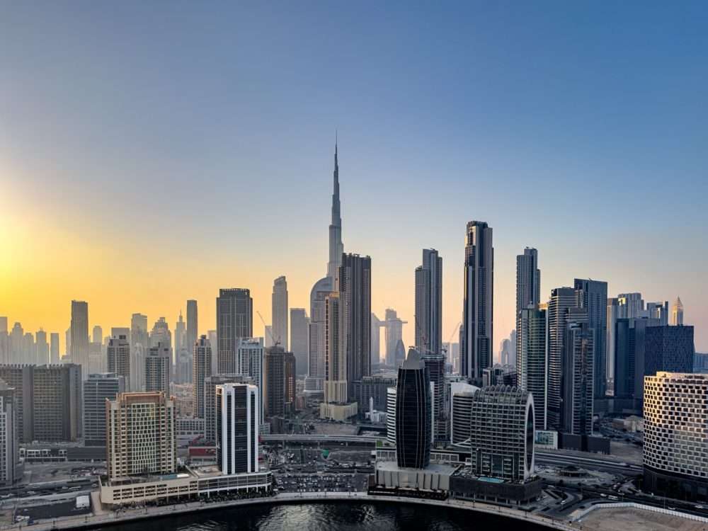 Business Bay aerial showing Burj Khalifa, corporate towers and Sheikh Zayed Road connectivity at sunset